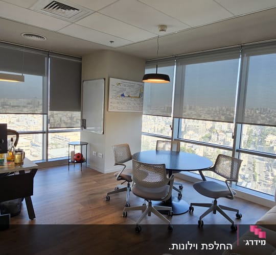 חלונות עם וילונות גלילה אפורים במשרד מודרני